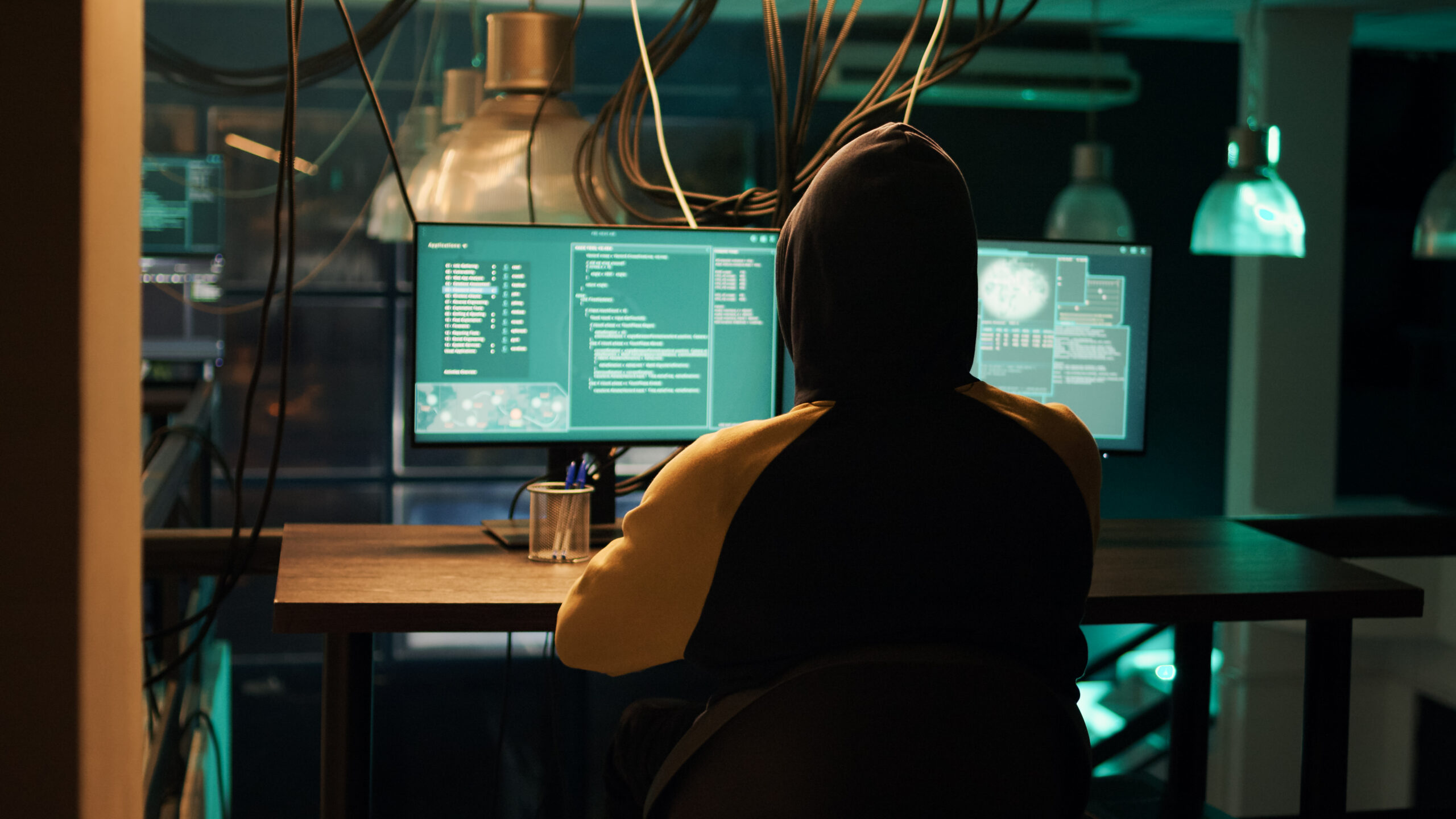 Hackers using network vulnerability to exploit security server, trying to break computer system at night. People working with multiple monitors to hack software, illegal hacktivism.